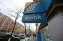 People walk past a branch of the Bank of Cyprus in Bucharest