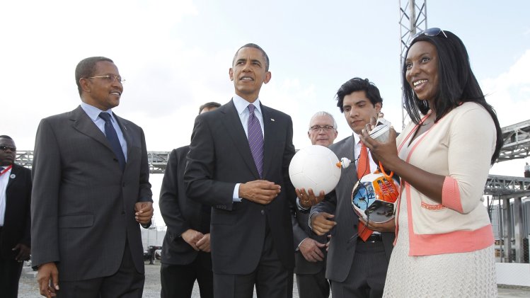 U.S. President Obama holds a soccer ball for the media alongside Tanzania's President Kikwete during a demonstration at the Ubungo Power Plant in Dar es Salaam