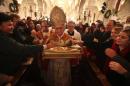 Latin patriarch of Jerusalem Fuad Twal carries a statuette of the baby Jesus during midnight mass in Bethlehem on December 25, 2010