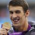 Michael Phelps of the U.S. poses with his gold medal after winning the men's 100m butterfly final during the London 2012 Olympic Games at the Aquatics Centre