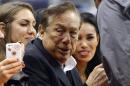 In this photo taken on Friday, Oct. 25, 2013, Los Angeles Clippers owner Donald Sterling, center, and V. Stiviano, right, watch the Clippers play the Sacramento Kings during the first half of an NBA basketball game, in Los Angeles. The NBA is investigating a report of an audio recording in which a man purported to be Sterling makes racist remarks while speaking to Stiviano. NBA spokesman Mike Bass said in a statement Saturday, April 26, 2014, that the league is in the process of authenticating the validity of the recording posted on TMZ's website. Bass called the comments "disturbing and offensive." (AP Photo/Mark J. Terrill)