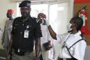 Immigration officer uses an infra-red laser thermometer to examine a policeman on his arrival at Nnamdi Azikiwe International Airport in Abuja
