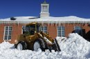 A plow clears a path outside Poquonock Elementary School in Windsor, Conn., Sunday, Feb. 10, 2013. A howling storm across the Northeast left much of the New York-to-Boston corridor covered with more than three feet of snow on Friday into Saturday morning. (AP Photo/Jessica Hill)