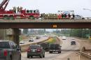 Firefighters and RCMP officers greet Fort McMurray residents from an overpass on Highway 63 just outside Fort McMurray, Alberta on June 1, 2016