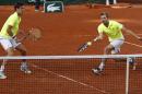French pair Julien Benneteau, right, and Edouard Roger-Vasselin return the ball to Spanish pair Marcel Granollers and Marc Lopez during their final match of the French Open tennis tournament at the Roland Garros stadium, in Paris, France, Saturday, June 7, 2014. (AP Photo/Darko Vojinovic)