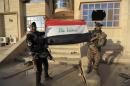 Iraq's elite counterterrorism force soldiers raise an Iraqi flag in front of the main church in Bartella, Iraq, Friday, Oct. 21, 2016. By Thursday, the Iraqi forces had advanced as far as Bartella, a historically Christian town some nine miles (15 kilometers) from Mosul's outskirts. (AP Photo/Khalid Mohammed)