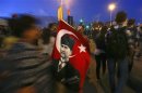 A woman sells Turkish flags with an image of the founder of modern Turkey depicted on them as anti-government protesters gather in Istanbul's Taksim square