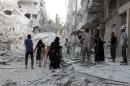 A Syrian family leaves the area following a reported airstrike on September 23, 2016, on the al-Muasalat area in the northern Syrian city of Aleppo