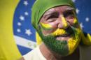 A protester with his face painted holds a flag during a protest at Copacabana beach in Rio de Janeiro, Sunday, April 12, 2015. Anti-government demonstrators began streaming into the streets of cities throughout Brazil on Sunday to demand the impeachment of President Dilma Rousseff. (AP Photo/Felipe Dana)