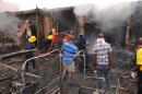 Firefighters extinguish a fire at the scene of a bomb blast at Terminus market in the central city of Jos on May 20, 2014