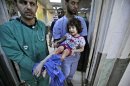 Medics carry Fatima Qassem, 6, whose legs were badly injured when government forces fired on her family's car, into the emergency room in a hospital in Aleppo, Syria, Tuesday, Sept. 11, 2012. (AP Photo/Muhammed Muheisen)