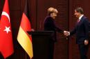 German Chancellor Merkel shakes hands with Turkish Prime Minister Davutoglu during a joint news conference in Ankara