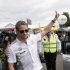 McLaren driver Jenson Button of Britain waves to fans after he arrived at Albert Park track for the Australian Formula One Grand Prix in Melbourne, Australia, Thursday, March 14, 2013. The season-opening race is scheduled for this weekend. (AP Photo/Rob Griffith)