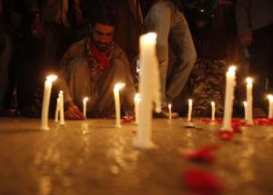 A man lights candles to mourn the victims from the &hellip;