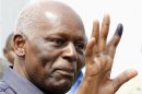 Angola's President Jose Eduardo dos Santos shows off his inked finger to photographers after casting his vote during national elections in the capital Luanda
