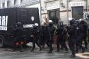 French riot officers patrol in Longpont, north of Paris, France, Thursday, Jan. 8, 2015. Scattered gunfire and explosions shook France on Thursday as its frightened yet defiant citizens held a day of mourning for 12 people slain at a Paris newspaper. French police hunted down the two heavily armed brothers suspected in the massacre to make sure they don't strike again. (AP Photo/Thibault Camus)