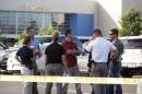 Investigators stand outside a movie theatre where a man shot and killed filmgoers Thursday night in Lafayette, Louisiana