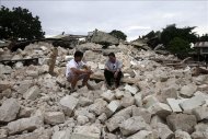 Dos hombres permanecen sentados entre los escombros de la iglesia de Nuestra Señora de la Luz, destruida por el terremoto de 7,2 grados del pasado martes, en la localidad de Loon, en la provincia de Bohol (Filipinas), el pasado 17 de octubre de 2013. EFE/Archivo