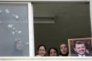 School children holding a picture of King Abdullah II watch out a window of the Swaifiyeh Secondary School for Girls in Amman on May 22, 2005