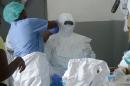 Medical workers at the John Fitzgerald Kennedy hospital of Monrovia put on their protective suit before going to the high-risk area of the hospital, on September 3, 2014