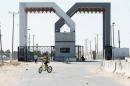 A Palestinian security officer sits near the gate under Palestinian control at the Rafah border crossing with Egypt in the southern Gaza Strip, October 25, 2014