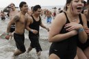 People react after taking the plunge in 30-degree temperatures during the 110th annual Coney Island Polar Bear Club ocean swim at Coney Island in New York, Tuesday, Jan. 1, 2013. (AP Photo/Kathy Willens)