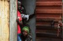 Members of the Fofah family peek through the door as they observe quarantine at home in Freetown, November 7, 2014