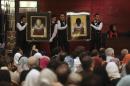 Iranian auction workers hold a pair of paintings of Iranian artist Aydin Aghdashlou in Tehran Art Auction at the Azadi Hotel in Tehran, Iran, Friday, May 27, 2016. (AP Photo/Vahid Salemi)
