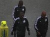 Referee Coulibaly and his assistants Diarra and Bouende-Malonga walk on field in heavy rain before African Nations Cup Group A soccer match between Zambia and Libya at Estadio de Bata