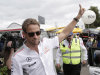 McLaren driver Jenson Button of Britain waves to fans after he arrived at Albert Park track for the Australian Formula One Grand Prix in Melbourne, Australia, Thursday, March 14, 2013. The season-opening race is scheduled for this weekend. (AP Photo/Rob Griffith)