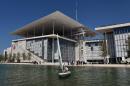 A man sails in front of the newly built Athens national Opera (L) and library buildings at the Stavros Niarchos Cultural Center in an Athens suburb on June 24, 2016