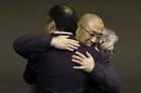Kenneth Bae, center, who had been held in North Korea since 2012, is hugged after arriving Saturday, Nov. 8, 2014, at Joint Base Lewis-McChord, Wash., after they were freed during a top-secret mission. (AP Photo/Ted S. Warren)