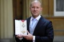Jonathan Ive, senior vice president of industrial design at Apple Inc poses with his with his KBE award after an investiture ceremony at Buckingham Palace in London