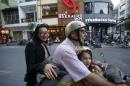 Quynh Pham, the owner of art gallery Galerie Quynh, rides on a moped with her husband Robert and daughter Nia An in Ho Chi Minh City