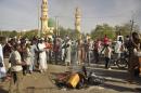 People gather at the site of a bomb explosion in Kano, Nigeria, Friday Nov. 28, 2014. An explosion tore through the central mosque in Nigeria's second-largest city on Friday, and officials feared the casualty toll would be high. Capt. Ikechukwu Eze said the Friday blast occurred at the main mosque in the city of Kano. Hundreds had gathered to listen to a sermon in a region terrorized by attacks from the militant group Boko Haram. (AP Photo/Muhammed Giginyu)