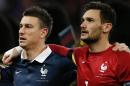 France's goalkeeper and captain Hugo Lloris (R) and defender Laurent Koscielny sing their country's national anthem before the start of the friendly football match between England and France at Wembley Stadium in west London on November 17, 2015