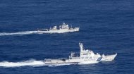 This handout photo taken by the Japan Coast Guard on September 18, shows a Chinese patrol boat (top) cruising the waters near a group of disputed islands, known as the Senkaku islands in Japan or Diaoyu islands in China, in the East China