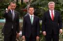 President Barack Obama, left, gives a thumbs up as he poses for photos with Mexico's President Enrique Pena Nieto, center, and Canada's Prime Minister Stephen Harper at the North American Leaders Summit in Toluca, Mexico, Wednesday, Feb. 19, 2014. The leaders met in part to highlight the economic cooperation that has grown since the North American Free Trade Agreement (NAFTA) joined the U.S., Canada and Mexico 20 years ago. (AP Photo/Canadian Press, Sean Kilpatrick)