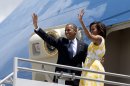 President Barack Obama and first lady Michelle Obama wave goodbye as they leave Orlando, Fla., Saturday, Aug. 10, 2013, en route to Martha's Vineyard, Mass., for a family vacation. (AP Photo/Jacquelyn Martin)