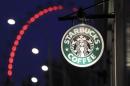 The sign outside a Starbucks coffee shop on in Westminster is seen with the London Eye in the background, in central London