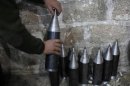 A Free Syrian Army fighter makes homemade missiles at a workshop in north Aleppo