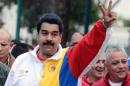 Venezuelan President Nicolas Maduro flashes the victory sign before voting during municipal elections, at a polling station in Caracas on December 8, 2013