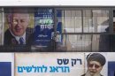 Passengers ride a bus with campaign advertisement and reflection of Netanyahu poster near Tel Aviv