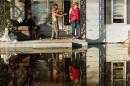Local residents gather on their front porch as a child shoots a bb gun while they seek refuge from flood waters due to Hurricane Matthew in Lumberton