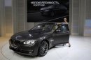 A model stands next to a BMW 7 series car during preparations for the Moscow International Automobile Salon