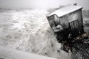 A house on the Plum Island seacoast in Newbury, Mass., sits partially collapsed into the churning surf, driven by winds from a slow-moving storm centered far out in the Atlantic Ocean, at high tide Friday morning, March 8, 2013. The storm dropped up to a foot of snow in some parts of New England, caused coastal flooding in Massachusetts and slowed the morning commute in the region to a slushy crawl. (AP Photo/Newburyport Daily News, Jim Vaiknoras)