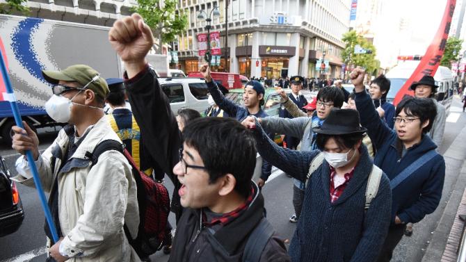 Members of a group of men calling themselves "Losers with Women" march through the Shibuya shopping district in Tokyo shouting anti-Christmas slogans on December 19, 2015
