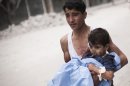In this Thursday, Oct. 11, 2012 photo, a Syrian youth holds a child wounded by Syrian Army shelling near Dar al-Shifa hospital in Aleppo, Syria. (AP Photo/ Manu Brabo)