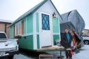 In this Jan. 16, 2014 photo Betty Ybarra, 48, stands outside a tiny houses she and her boyfriend live in, in Madison, Wis. It is the first house built by OM Build, which wants to build nine houses in Madison for the homeless. (AP Photo/Carrie Antlfinger)