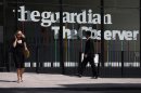 Pedestrians walk past the entrance of the Guardian newspaper building in London